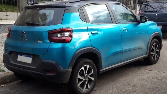 Citroën C3 azul com teto preto visto de traseira, estacionado junto ao meio-fio